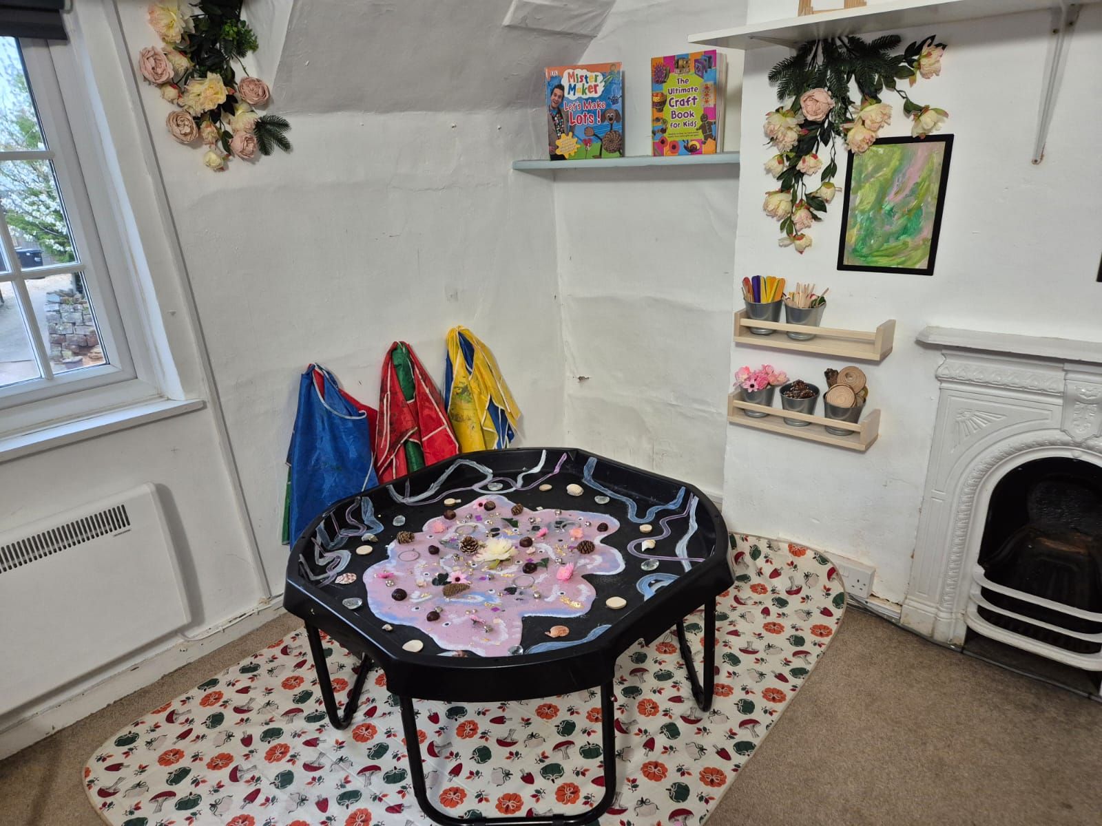 Tuff tray activity in the Toddler Room beside the fireplace